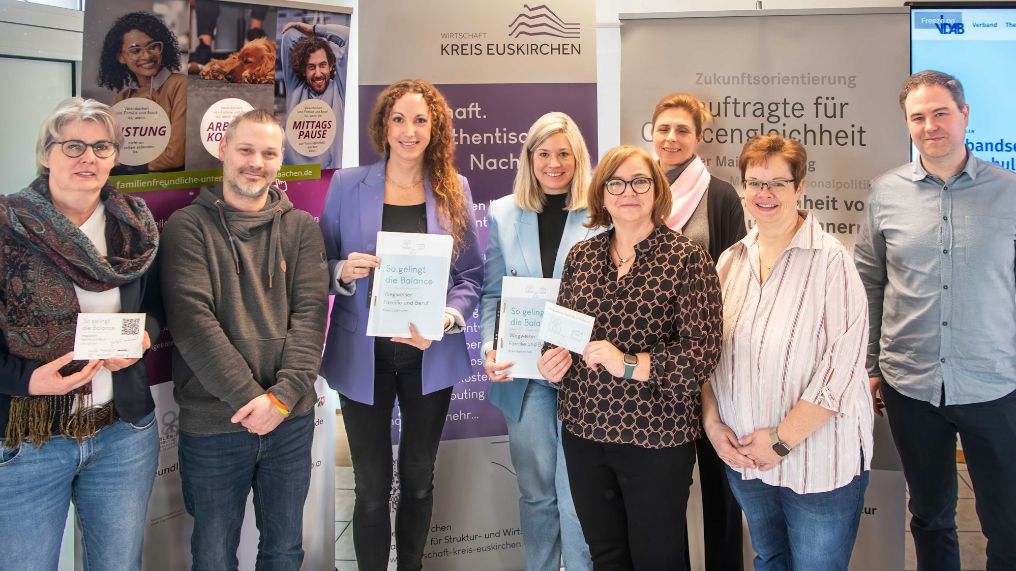 Das Bild zeigt zahlreiche Männer und Frauen, die vor mehreren Stellwänden den Wegweiser präsentieren.