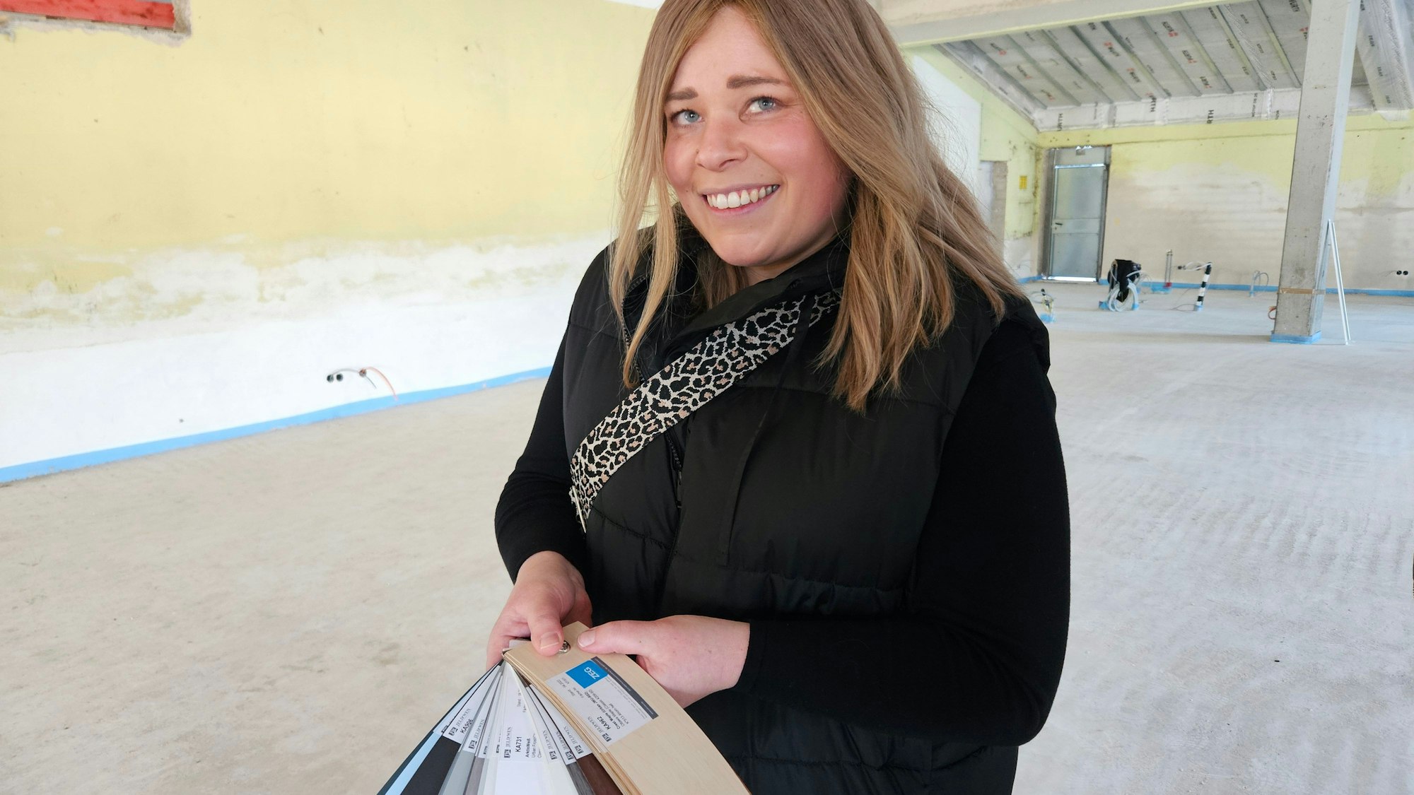 Nadine Schwendtner hält verschiedene Farbmuster in den Händen.