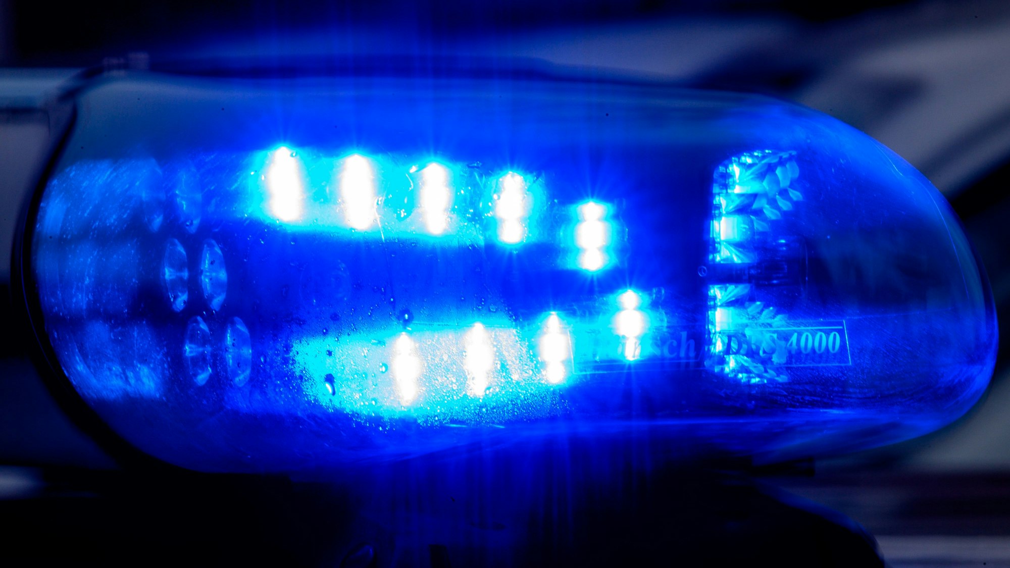 Blaulicht leuchtet auf einem Fahrzeug der Polizei.
