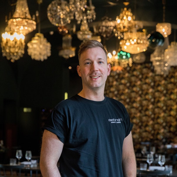 Zu sehen ist Eric Werner in seinem Restaurant „Augustin“. Er lächelt in die Kamera.