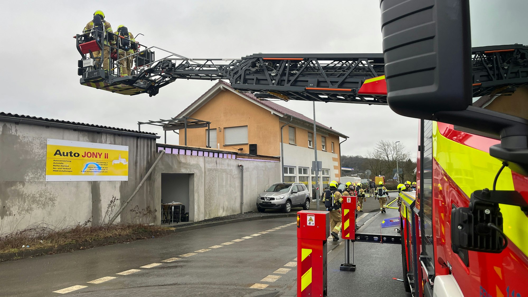 Im Korb einer Drehleiter stehen zwei Feuerwehrleute.
