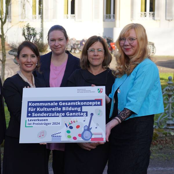 Bürgermeister Bernhard Marewski, Staatssekretärin Ministerium Kultur und Wissenschaft NRW Gonca Türkeli-Dehnert mit Katharina Baarhs, Mirjam Wandhoff und Anke Holgersson vom kommunalen Bildungsbüro Leverkusen halten die Auszeichnung für Kulturelle Bildung in der Hand