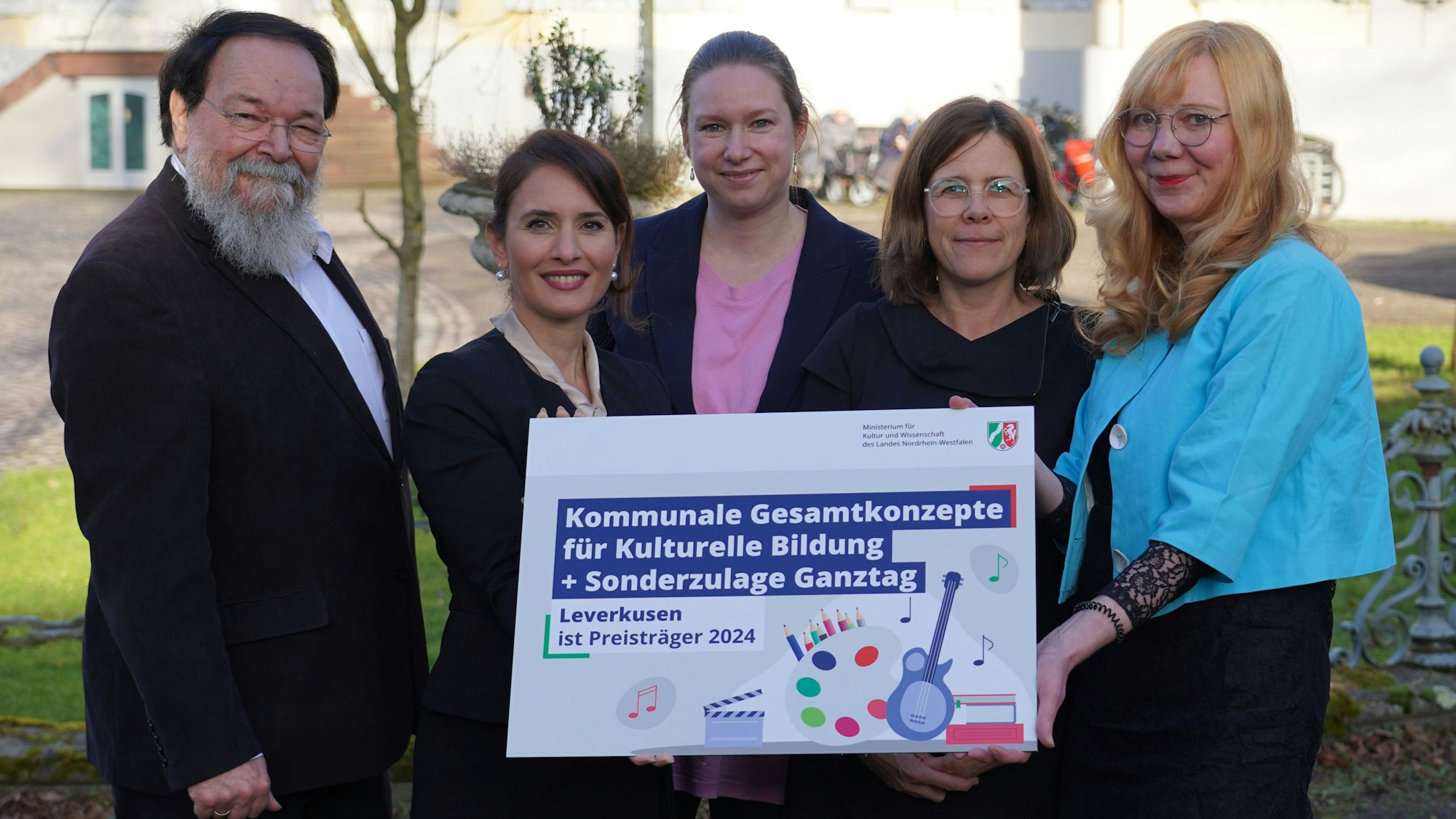 Bürgermeister Bernhard Marewski, Staatssekretärin Ministerium Kultur und Wissenschaft NRW Gonca Türkeli-Dehnert mit Katharina Baarhs, Mirjam Wandhoff und Anke Holgersson vom kommunalen Bildungsbüro Leverkusen halten die Auszeichnung für Kulturelle Bildung in der Hand