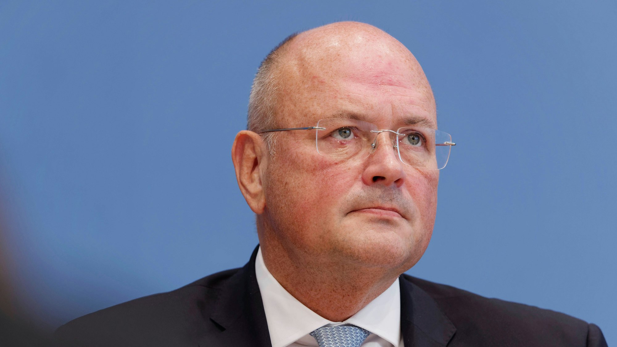 Arne Schönbohm ist im Porträt zu sehen, er schaut durch eine randlose Brille in die Ferne.