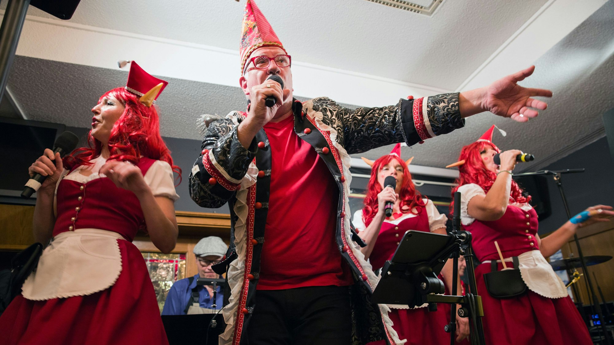 Sitzungspräsident Helmut Frangenberg und seine drei Brauhauselfen singen ein Lied.