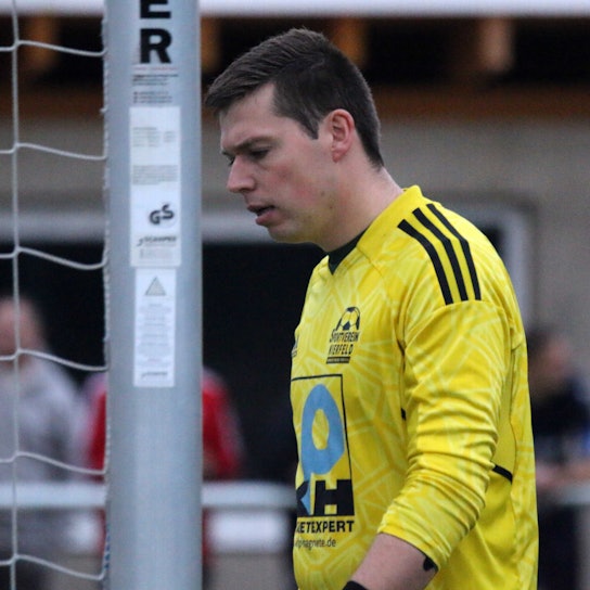 Niklas Maubach blickt, neben dem Pfosten stehend, grimmig zu Boden.
