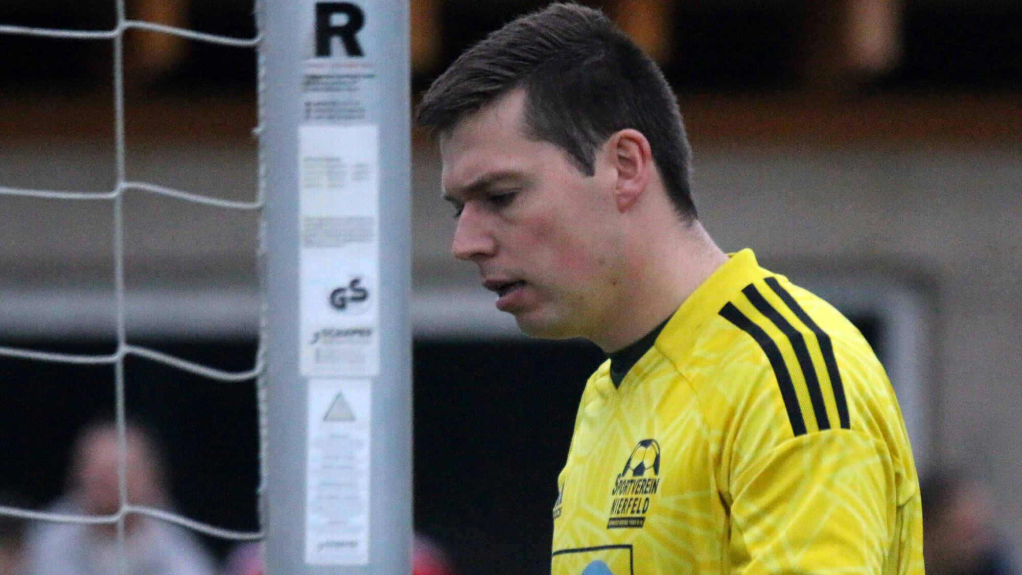 Niklas Maubach blickt, neben dem Pfosten stehend, grimmig zu Boden.