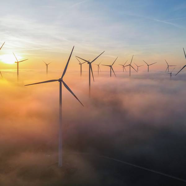 Die Morgensonne leuchtet über dem Nebel zwischen Windenergieanlagen im östlichen Brandenburg (Luftaufnahme mit einer Drohne).