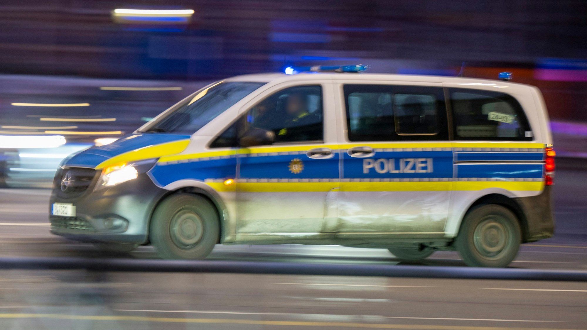Ein Polizeiauto fährt mit Blaulicht zu einem Einsatz.