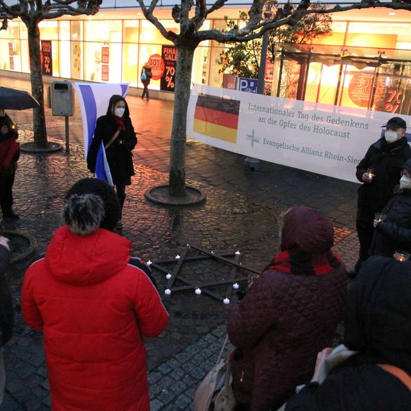 Teilnehmer einer Kundgebung mit einem großen Banner