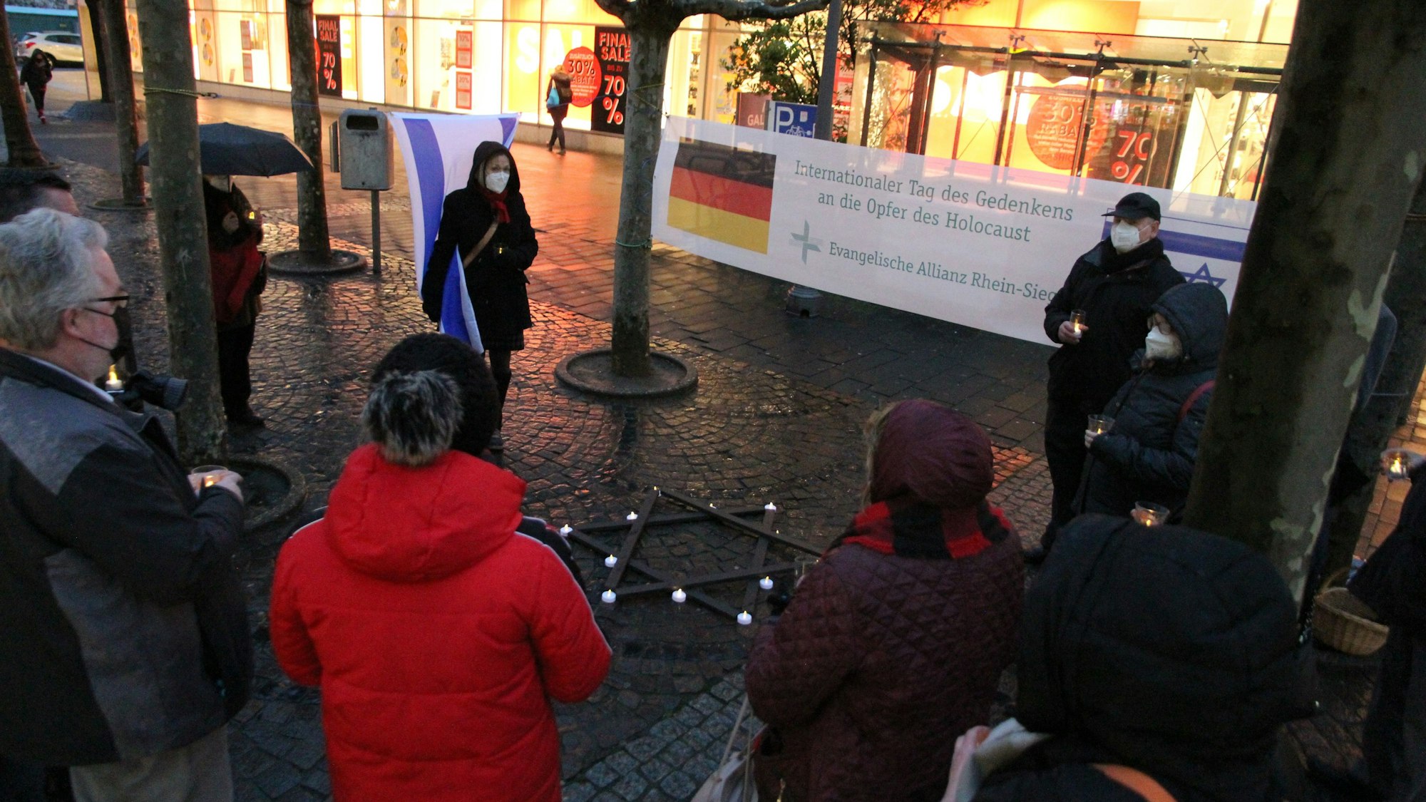 Teilnehmer einer Kundgebung mit einem großen Banner