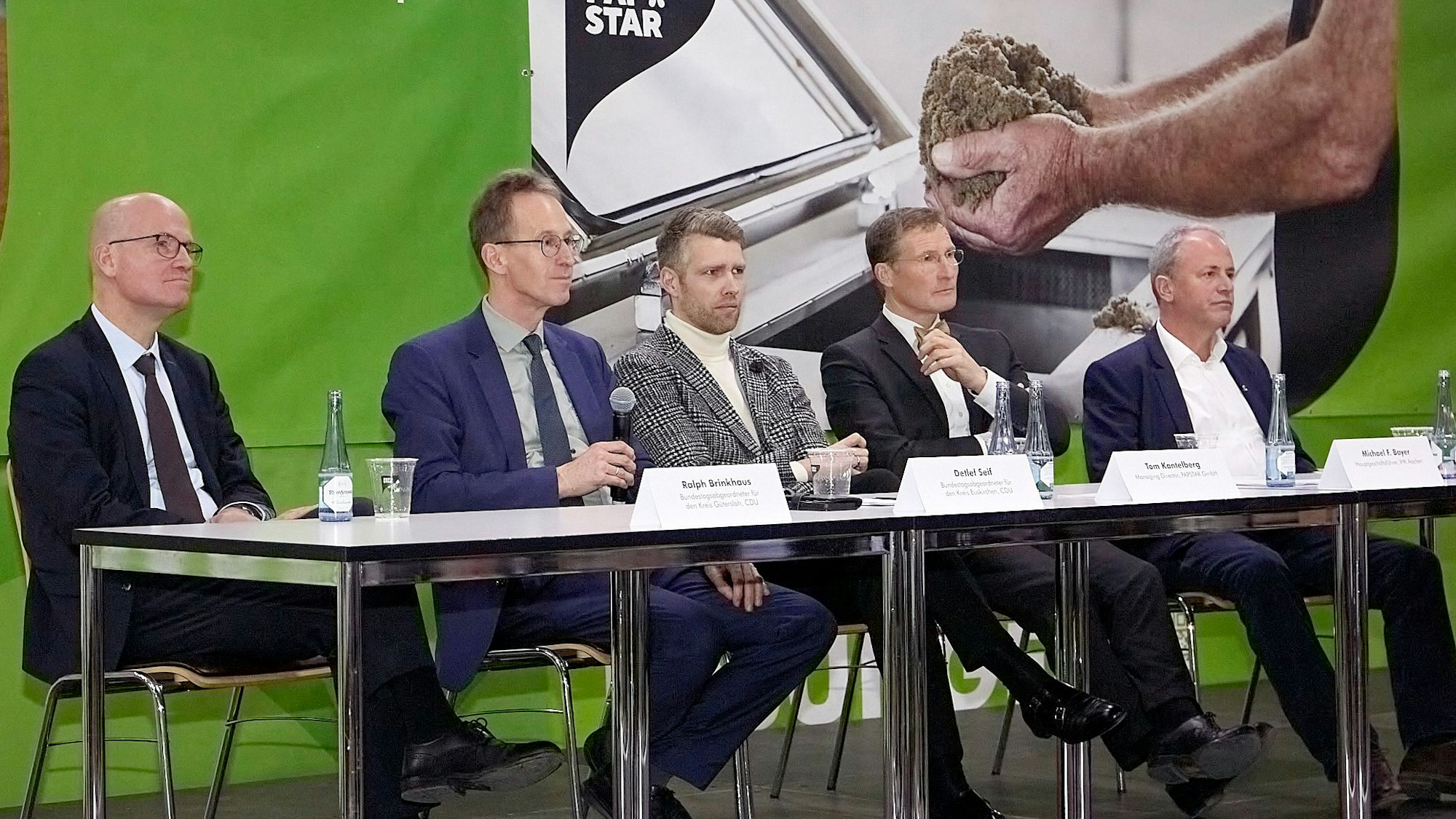 Fünf Männer sitzen bei einer Podiumsdiskussion in der Kaller Firma Papstar an einem Tisch.