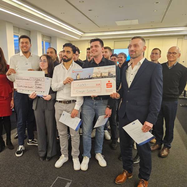 Viele Menschen halten „Preisgeld-Checks“ in den Händen und freuen sich.