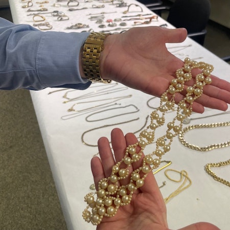 Das Bild zeigt eine Beamtin, die auf den Innenseiten ihrer Hände eine Goldkette präsentiert.