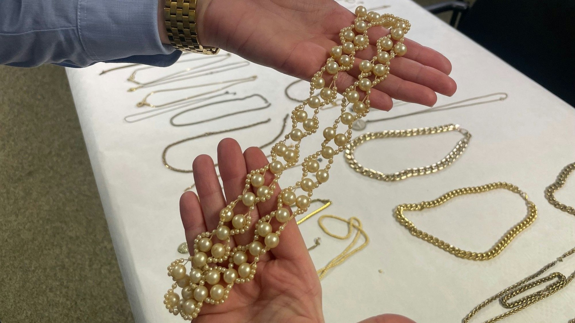 Das Bild zeigt eine Beamtin, die auf den Innenseiten ihrer Hände eine Goldkette präsentiert.