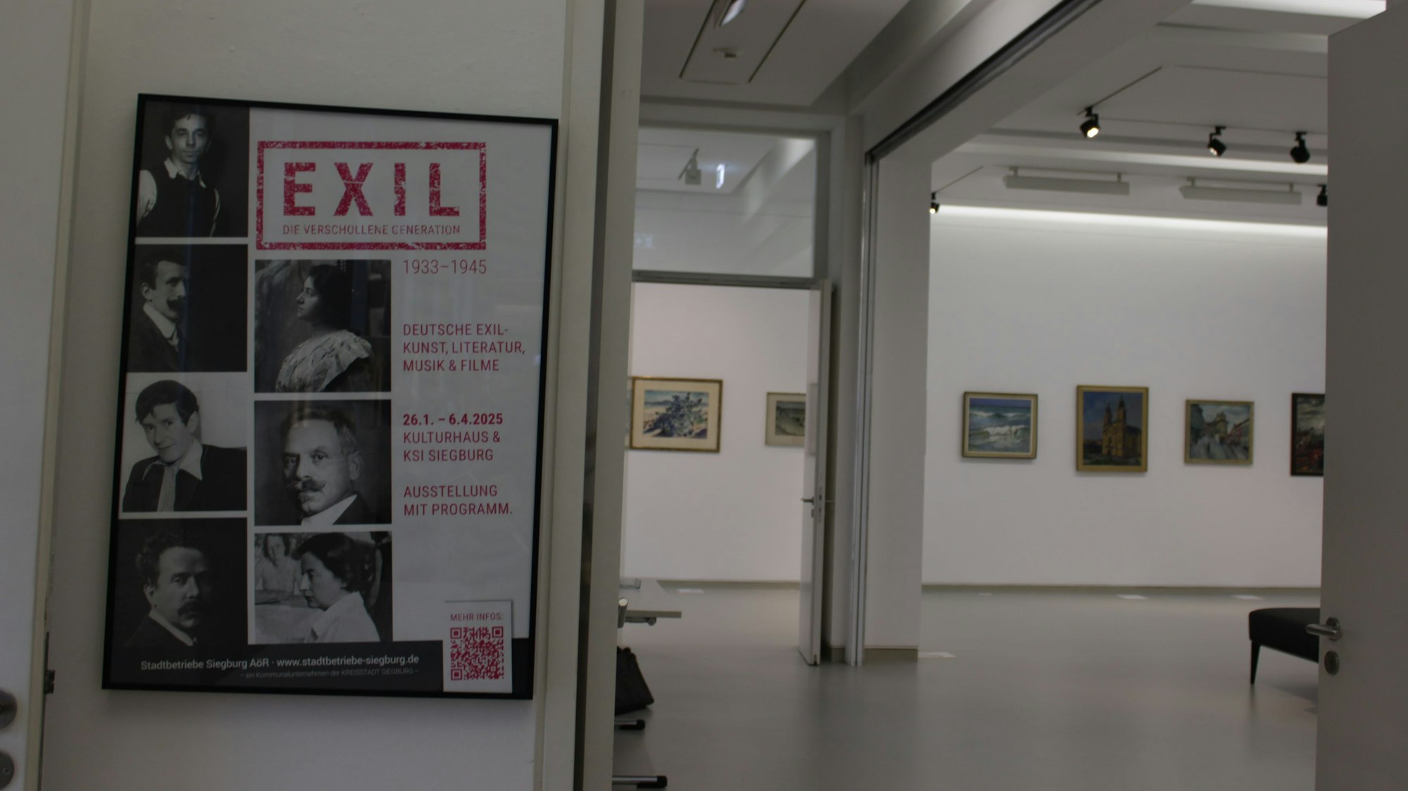 Ein heller Ausstellungsraum, in dem einige gerahmte Gemälde hängen. Am Eingang hängt ein Plakat mit dem Titel „Exil -Die verschollene Generation 1933 - 1945“