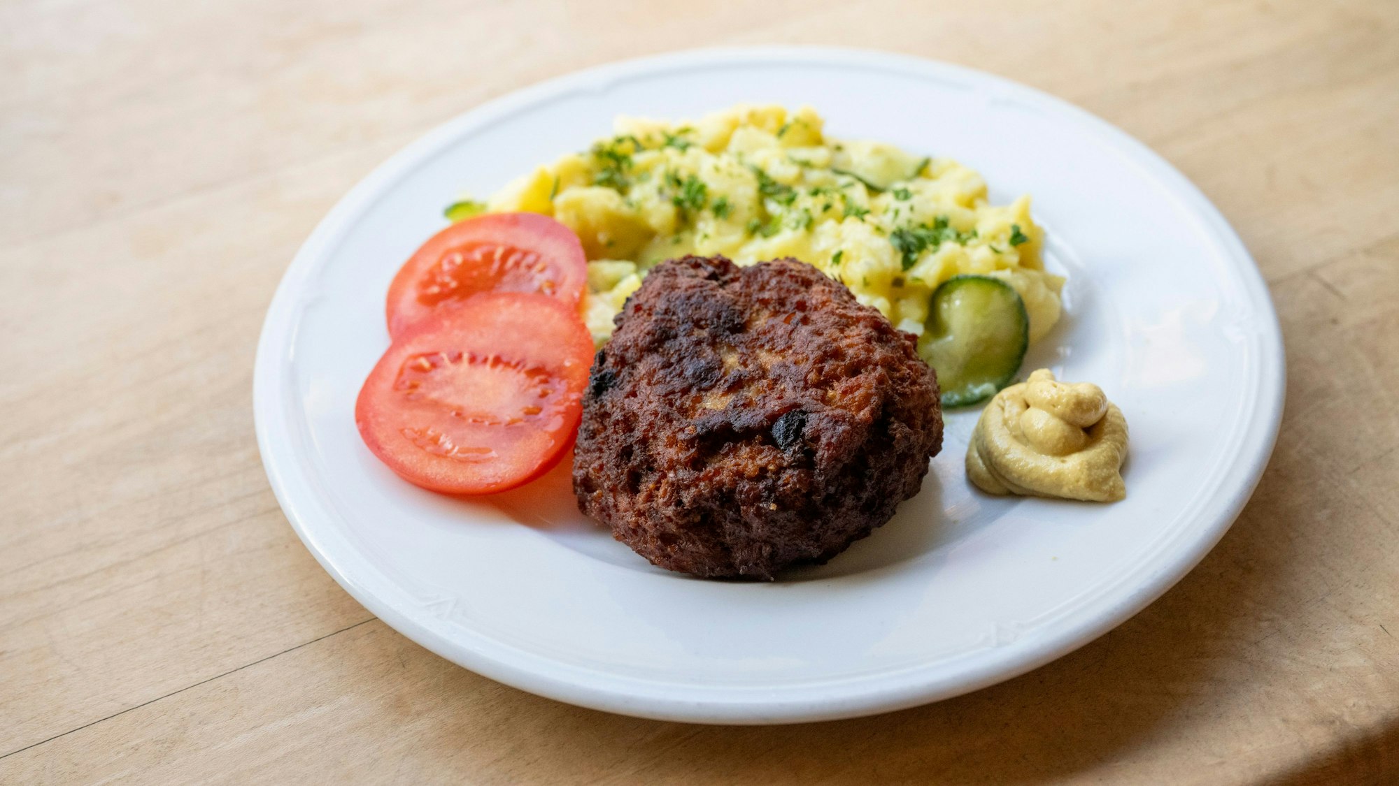 21.01.2025, Köln: Das Imbiss-Restaurant M. Mayer findet sich in der Venloer Straße. Frikadelle mit Kartoffelsalat. Gastrokolumne „Lieblingsort“ von Julia Floß über das „M. und M. Mayer“. Foto: Uwe Weiser