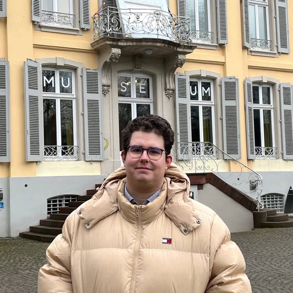 Ein Mann steht vor einem Gebäude.