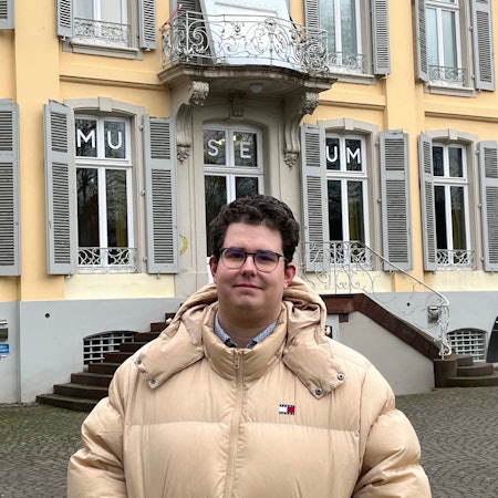 Ein Mann steht vor einem Gebäude.