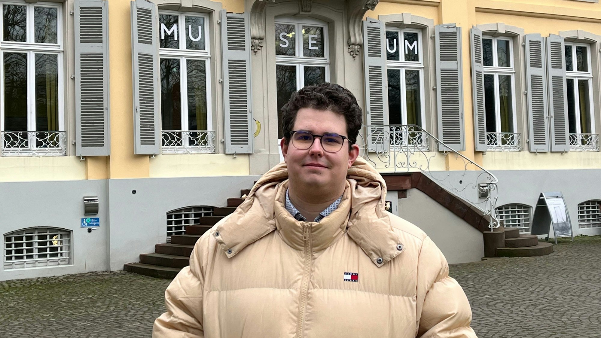Ein Mann steht vor einem Gebäude.