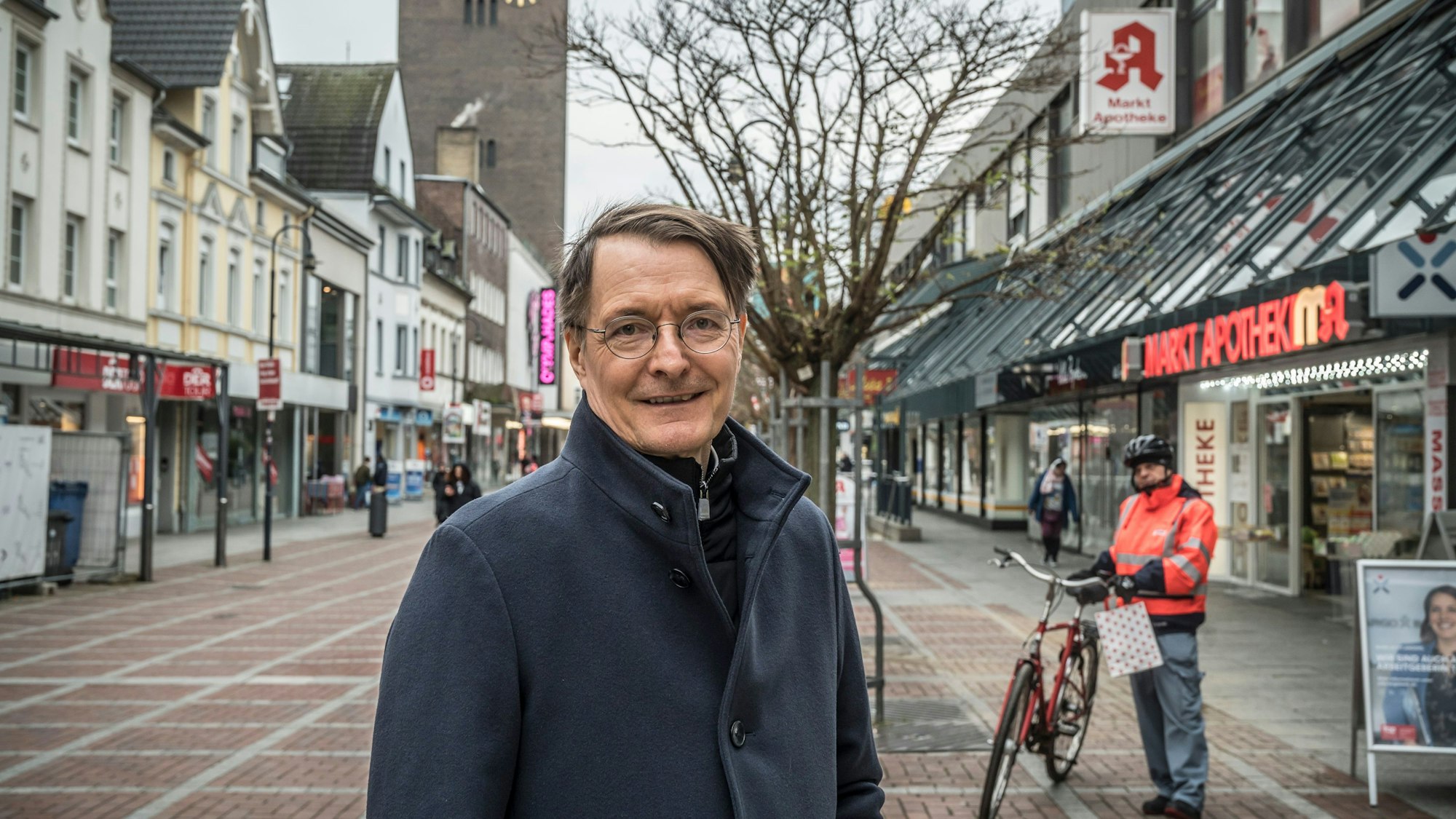 Ein Mann steht in einer Fußgängerzone.