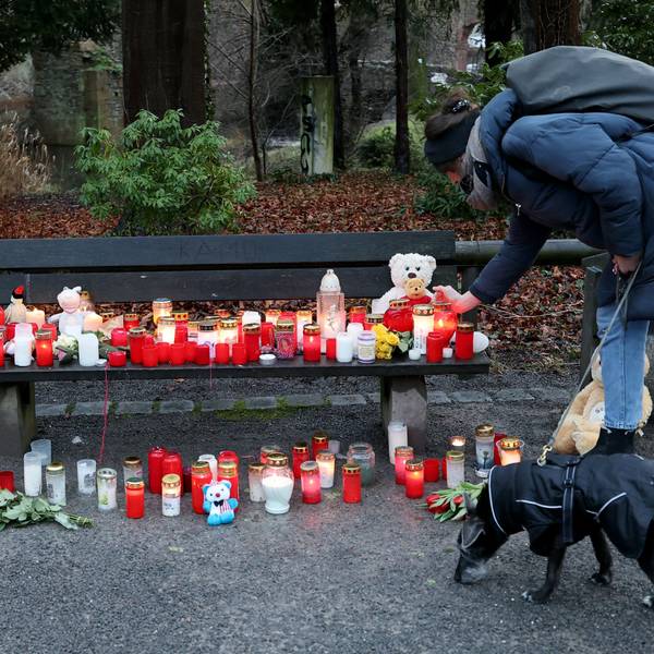 Eine Frau stellt eine Trauerkerze neben Blumen und Kuscheltieren nach dem tödlichen Angriff in einem Park am Tatort auf einer Bank ab.