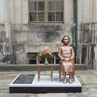 Die Friedensstatue in Dresden zeigt eine junge Frau, die auf einem Stuhl sitzt.