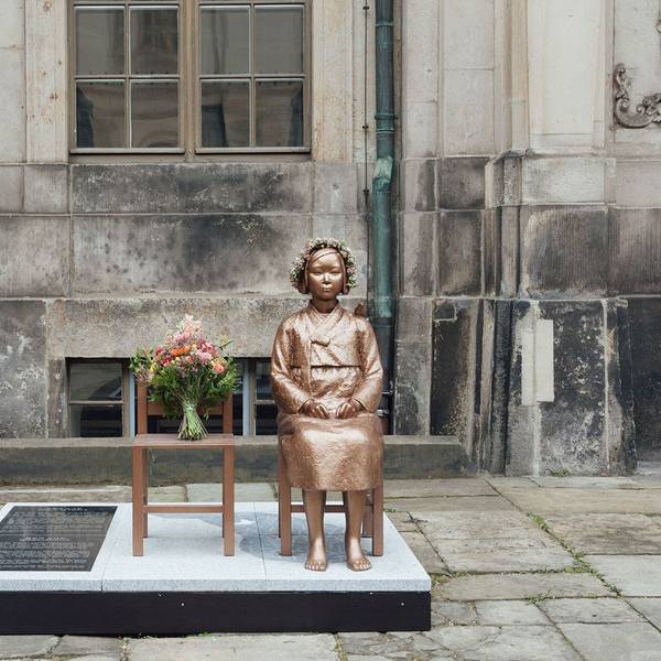 Bronze einer sitzenden Frau neben einem leeren Stuhl.