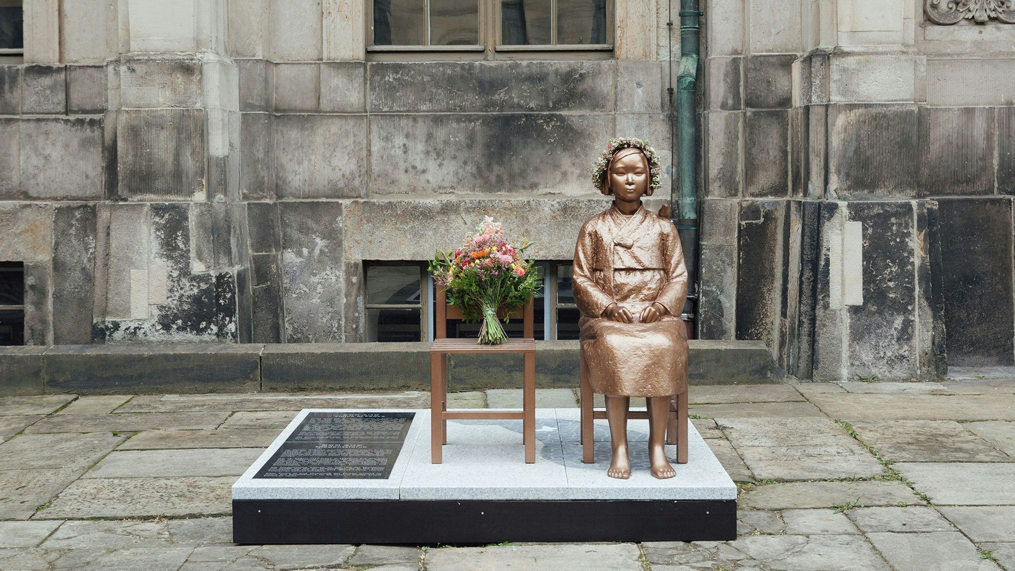 Die Friedensstatue in Dresden zeigt eine junge Frau, die auf einem Stuhl sitzt.