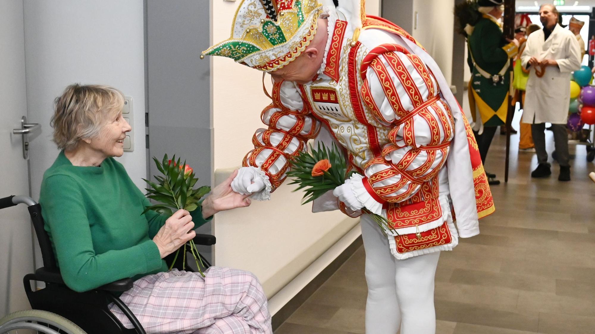 Prinz René I. übergibt Frau im Rollstuhl Strüßjer