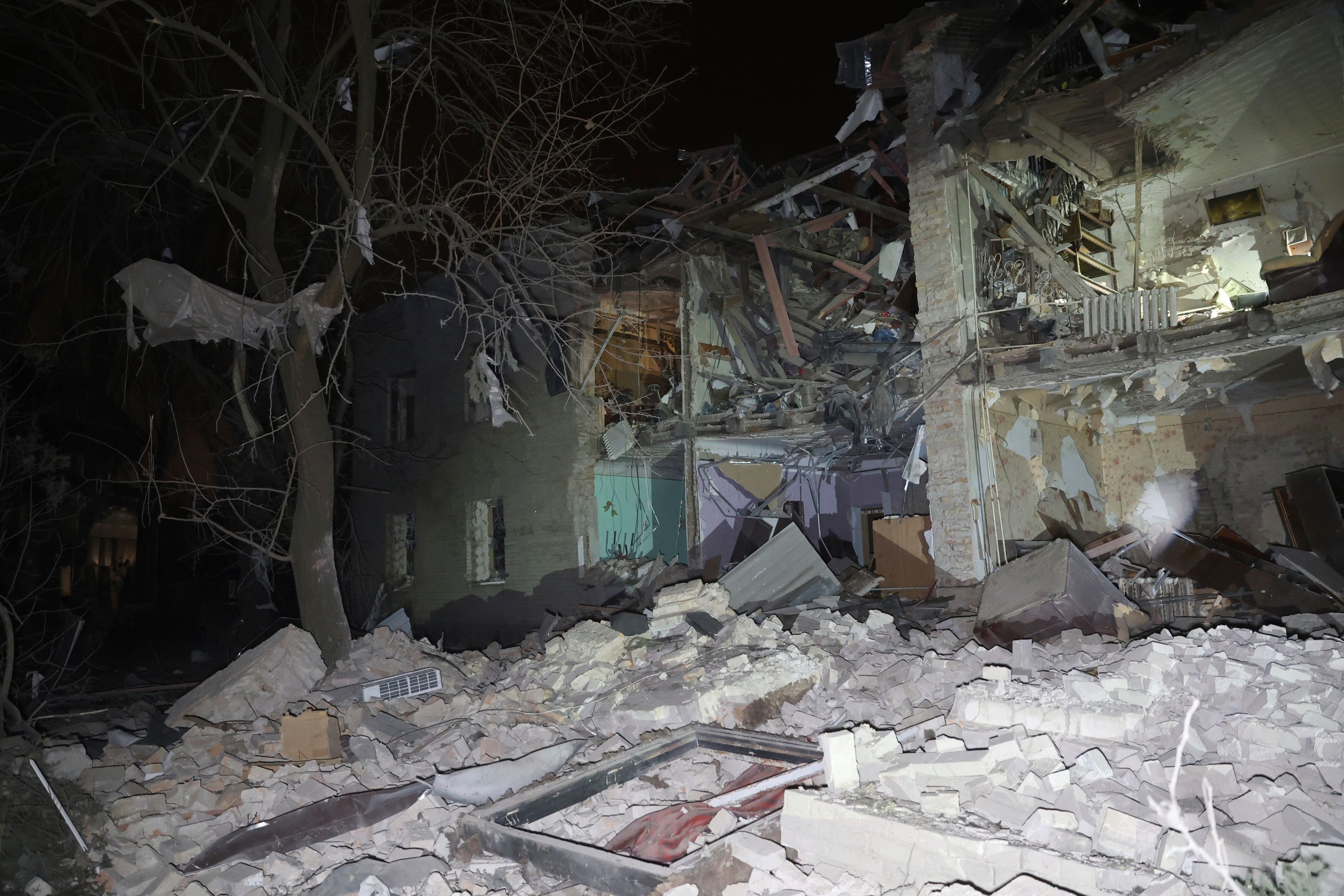 Ein Wohnhaus in Trümmern; die Front fehlt, vor dem Haus liegen Trümmer.