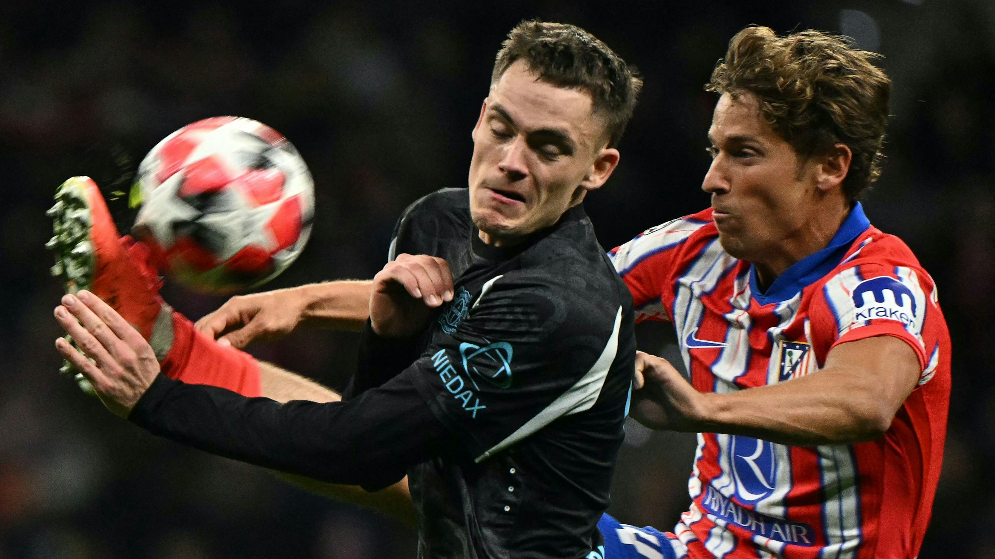 Leverkusens Florian Wirtz (l.) gegen Marcos Llorente von Atlético Madrid.