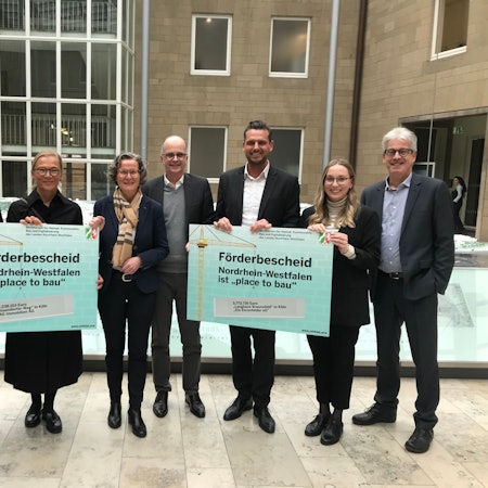 (v. l): Jörn Rickmann und Kathrin Möller von der GAG, Ministerin Ina Scharrenbach, Dezernent Markus Greitemann sowie Martin Bündgens und Sira Müller von der Wohnungsbaugenossenschaft "Die Ehrenfelder"und deren früherer Vorstand Werner Nußbaum