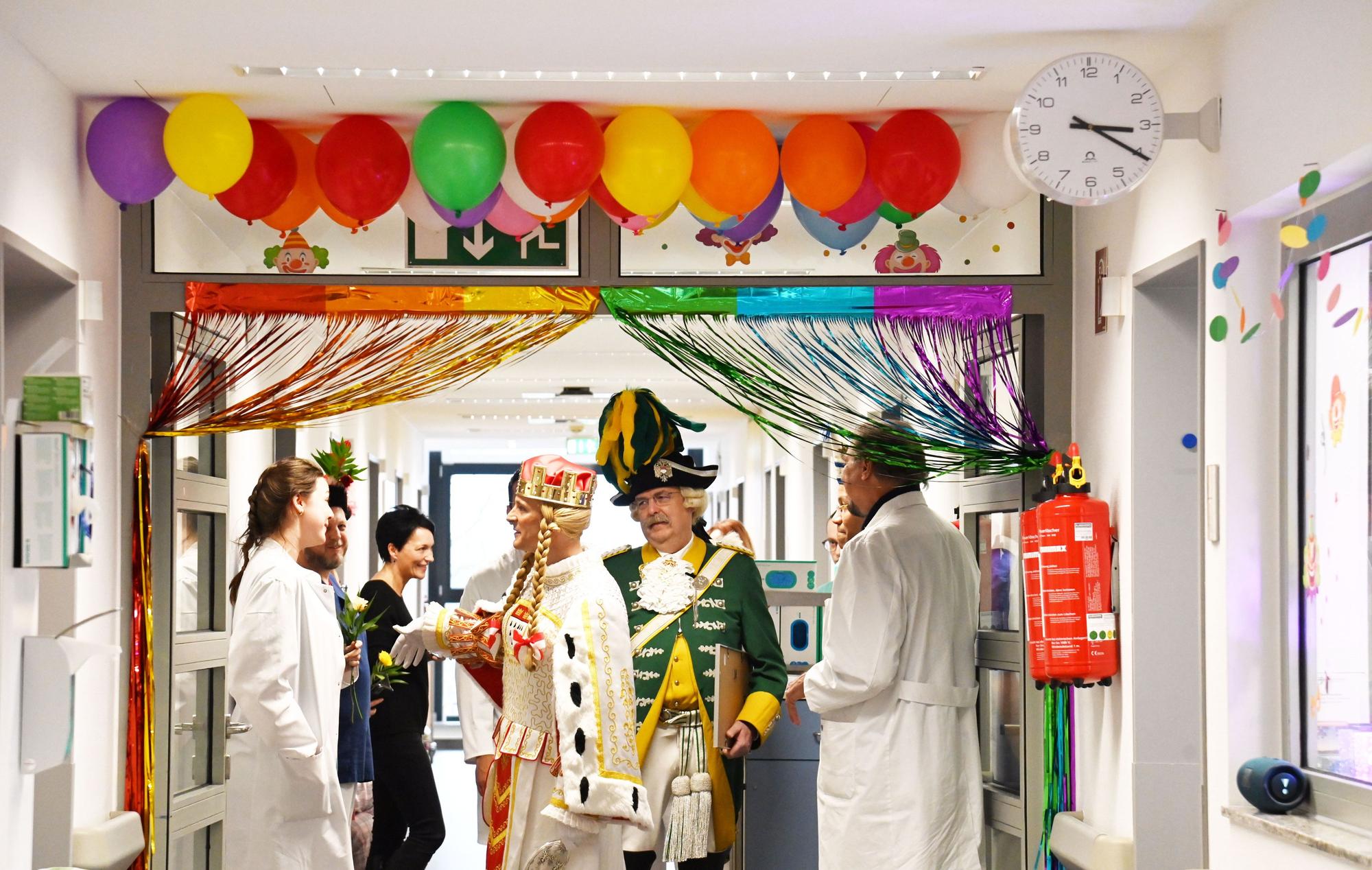 Krankenhausflur mit Luftballons und Girlande, im Gang steht Jungfrau Marlis mit Ärztinnen und Ärzten.