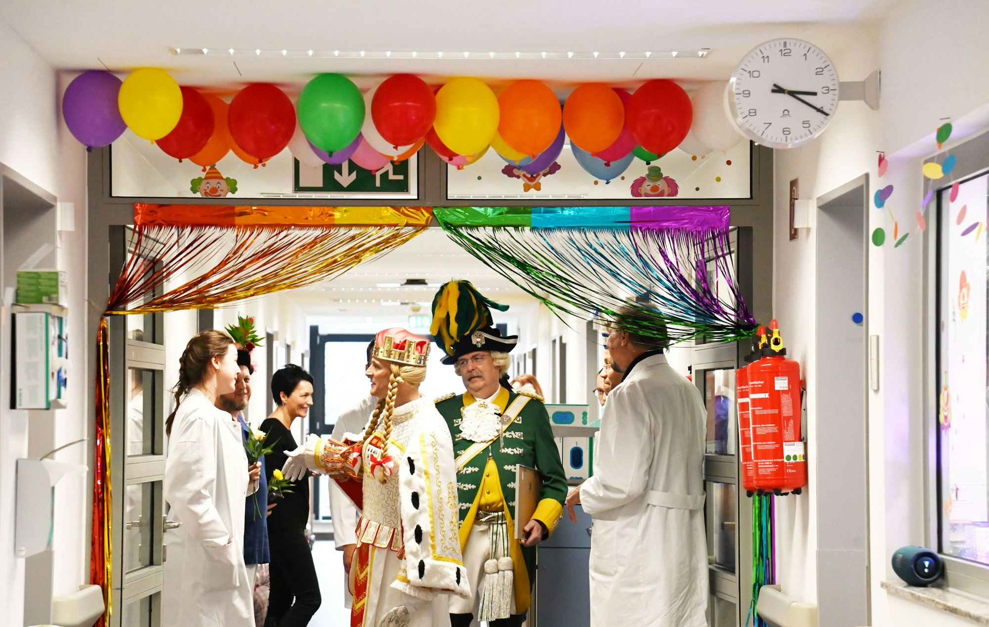 Krankenhausflur mit Luftballons und Girlande, im Gang steht Jungfrau Marlis mit Ärztinnen und Ärzten.