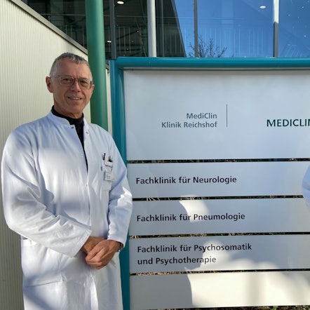 Matthias Schmalenbach, Chefarzt der Pneumologie an der Mediclin-Rehaklinik in Reichshof-Eckenhagen, und Jürgen Bonnert, Chefarzt der Neurologie und kommissarischer Chefarzt für Psychosomatik und Psychotherapie, stehen vor einem Klinikschild.