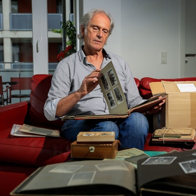 25.09.2024, Köln: Gerhard Richter sitzt auf dem Sofa und blättert Erinnerungsstücke seines Vaters durch.