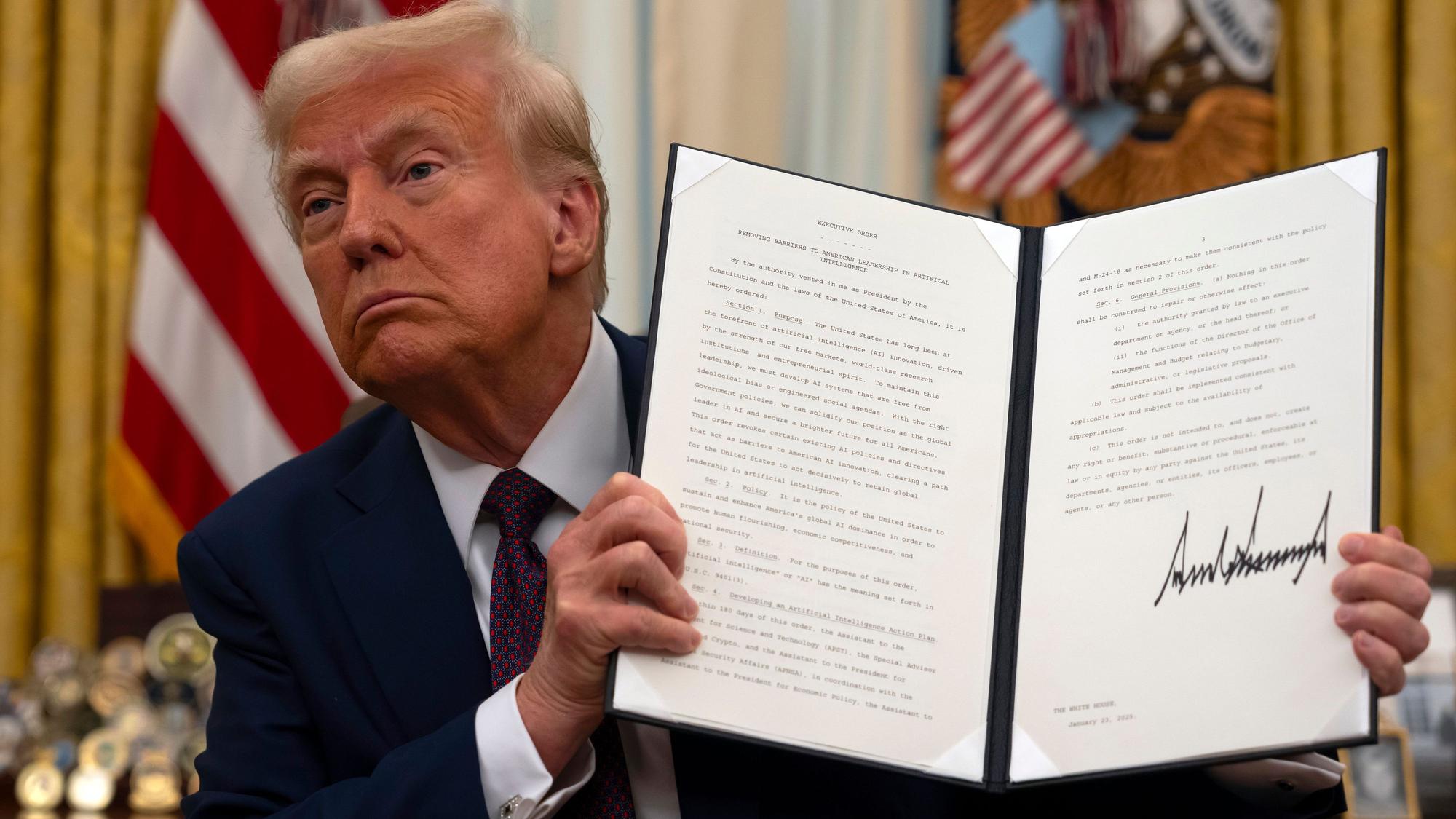 US-Präsident Donald Trump hält im Oval Office des Weißen Hauses eine unterzeichnete Anordnung zum Thema künstliche Intelligenz hoch.