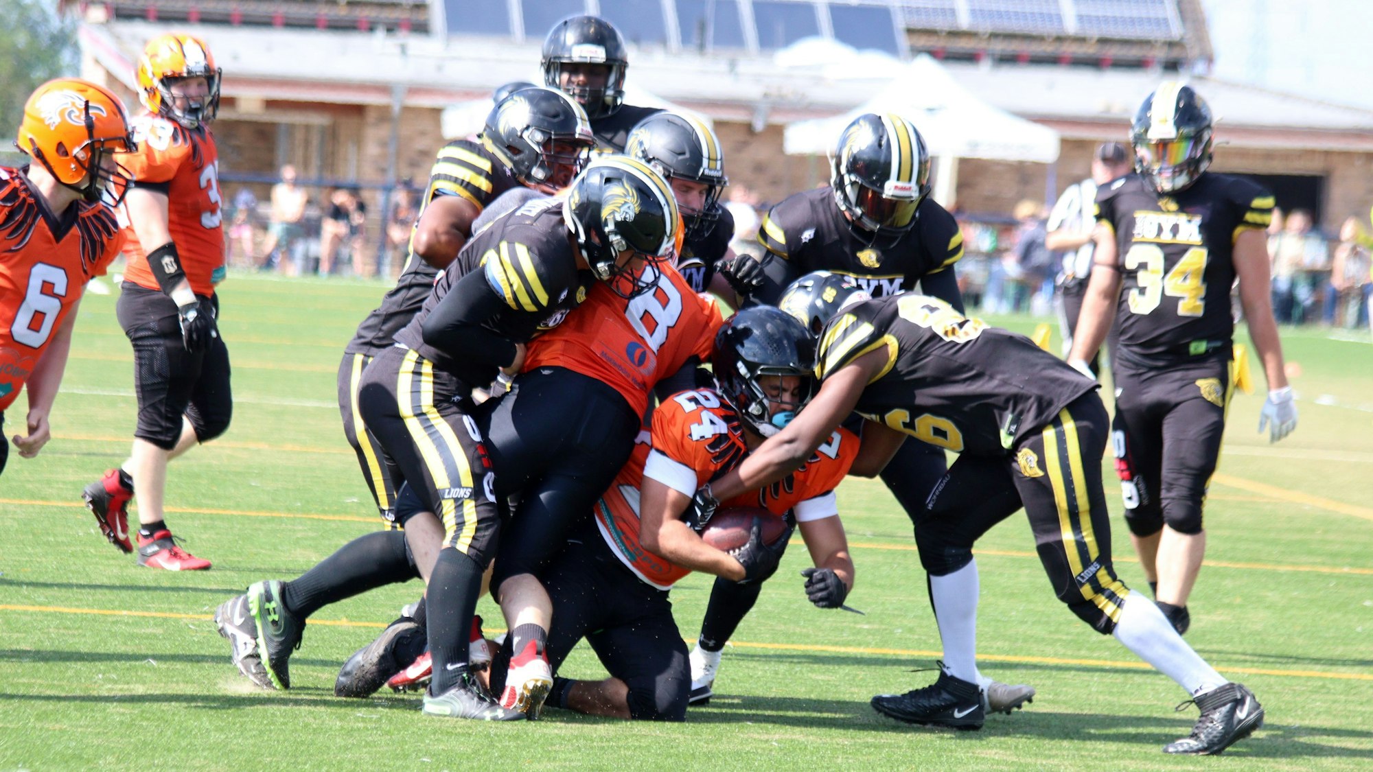 Eine Gruppe von Footballern kämpft auf einem Spielfeld um den Ball.