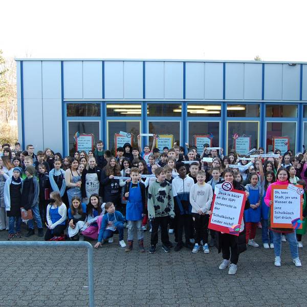 Schüler protestieren vor dem Schulgebäude.