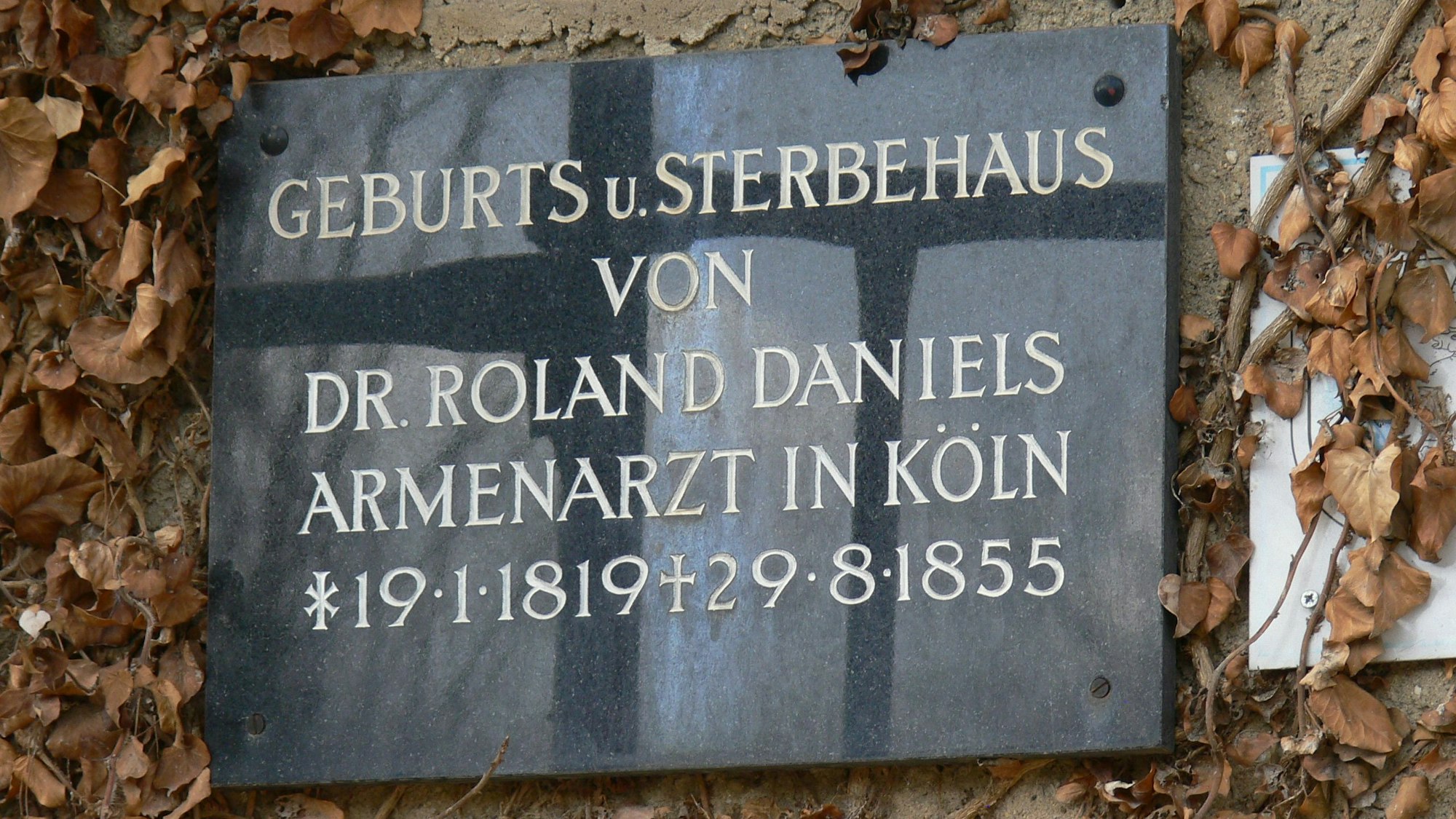 Zu sehen ist eine Marmorplakette, die an Roland Daniels erinnert.