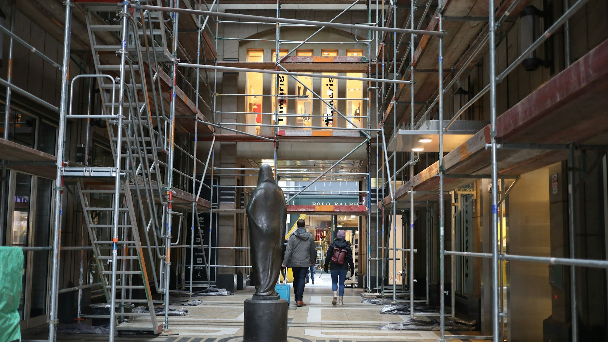 Die Skulptur Gaia steht etwas verloren zwischen den Gerüsten in der Stollwerck-Passage.