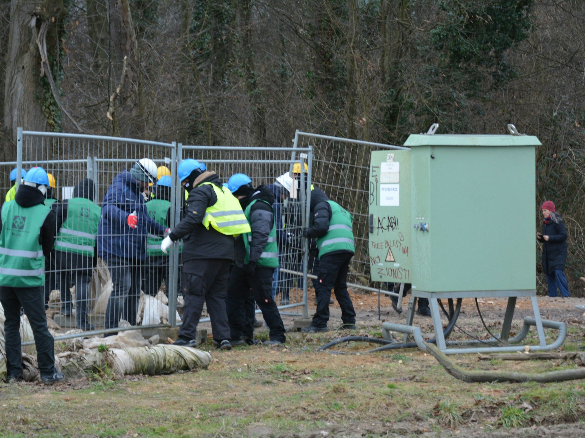 Das Bild zeigt mehrere Personen an einem Pumpenhäuschen.