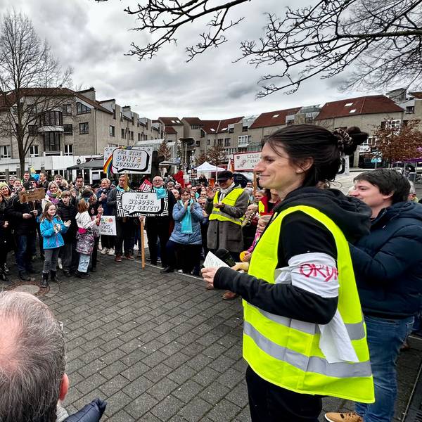 Teilnehmer einer Demonstration bilden einen Halbkreis.