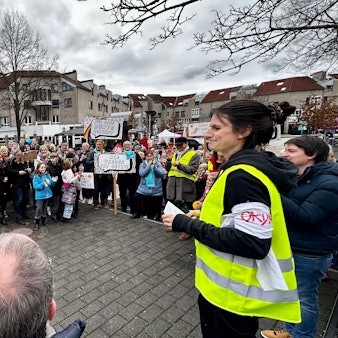Teilnehmer einer Demonstration bilden einen Halbkreis.