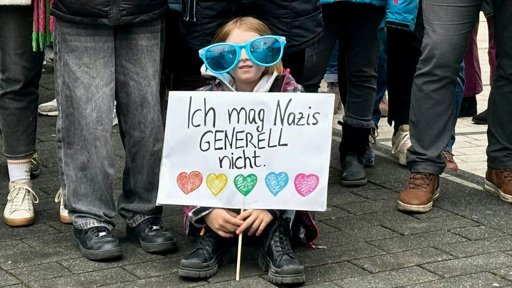 Ein Mädchen mit einem Plakat „Ich mag Nazis generell nicht“.