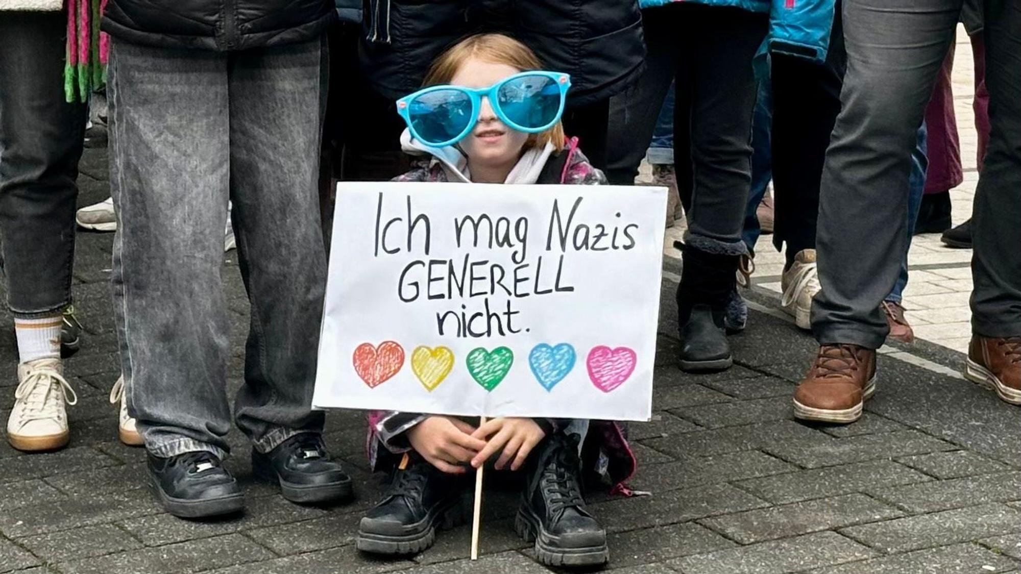 Ein Mädchen mit einem Plakat „Ich mag Nazis generell nicht“.