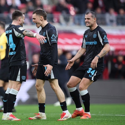 Bayer Leverkusen's Spanish midfielder #24 Aleix Garcia (L) celebrates scoring the 0-2 goal with his teammates Bayer Leverkusen's German midfielder #10 Florian Wirtz and Bayer Leverkusen's Swiss midfielder #34 Granit Xhaka during the German first division Bundesliga football match RB Leipzig vs Bayer 04 Leverkusen in Leipzig, eastern Germany on January 25, 2025. (Photo by Ronny HARTMANN / AFP) / DFL REGULATIONS PROHIBIT ANY USE OF PHOTOGRAPHS AS IMAGE SEQUENCES AND/OR QUASI-VIDEO