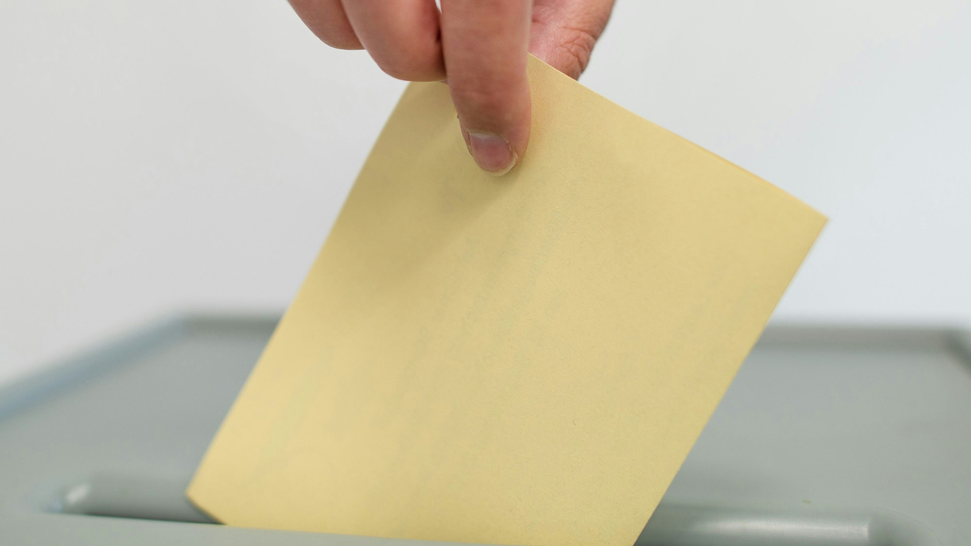 Ein Stimmzettel wird in eine Wahlurne geworfen. (Symbolbild)