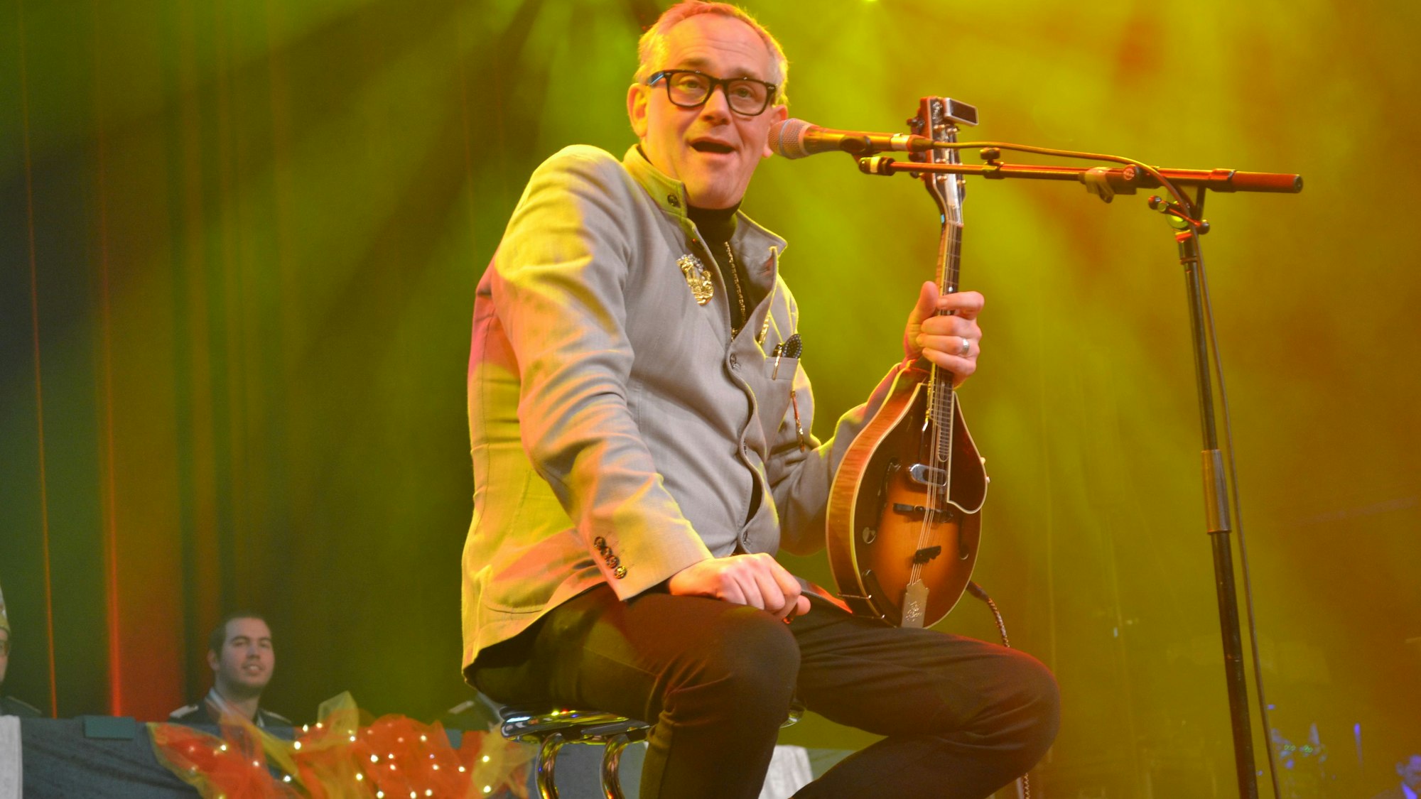 Ein Mann mit einer Mandoline auf einer Bühne.
